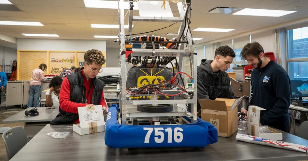 CHS students work on a large robot in a technical lab
